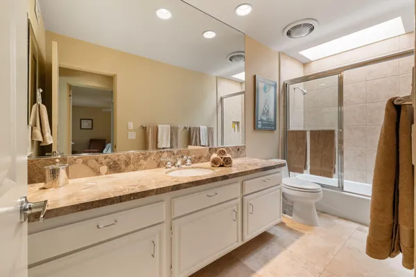 a bathroom with a double vanity sink toilet and shower