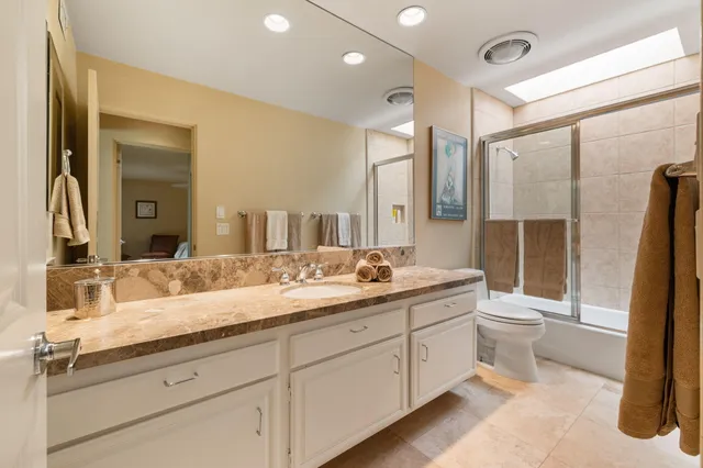 a bathroom with a double vanity sink toilet and shower