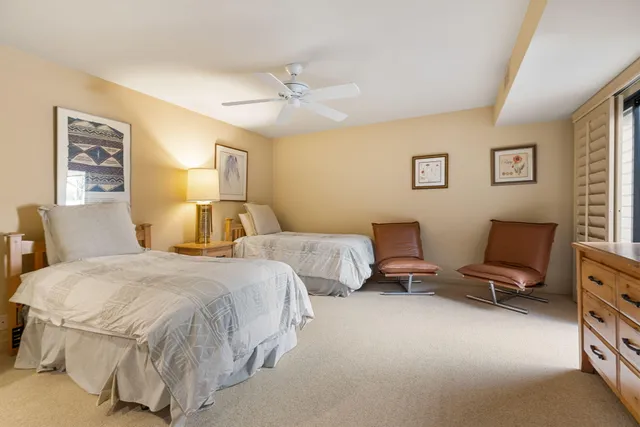 a bedroom with two beds and painting on the wall