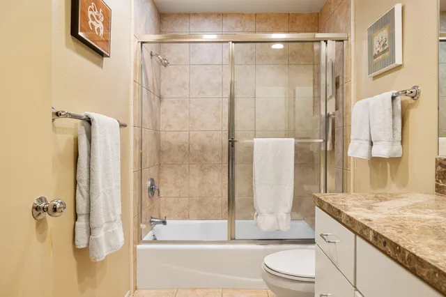 a bathroom with a granite countertop sink toilet and shower