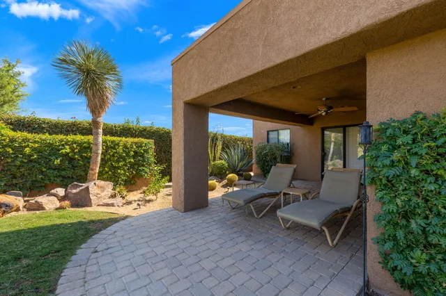 a view of a patio with a table and chairs under an umbrella