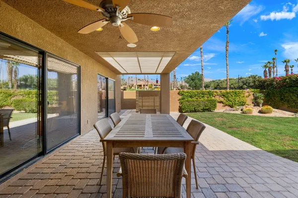 a patio with a table and chairs and a barbeque