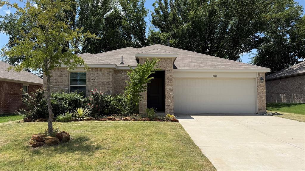 2210 Alamo Road Sherman, TX 75090 - Photo 1 of 17 Brick exterior with an attached two-car garage, concrete driveway, and a gabled roof