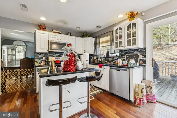 a kitchen filled with stainless steel appliances kitchen island granite countertop a refrigerator and microwave