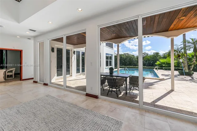 a view of a patio with a table and chairs in front of it