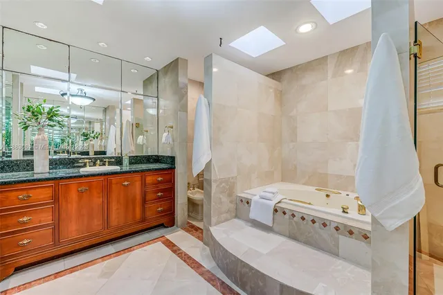 a bathroom with a tub sink and mirror