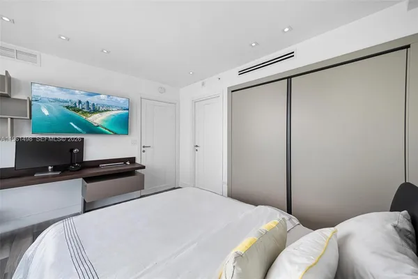 a bedroom with a bed and a flat screen tv