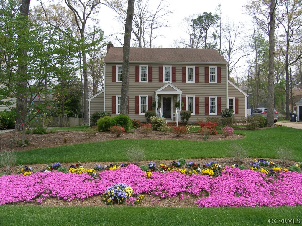 a front view of a house with a yard and fountain in front of statue