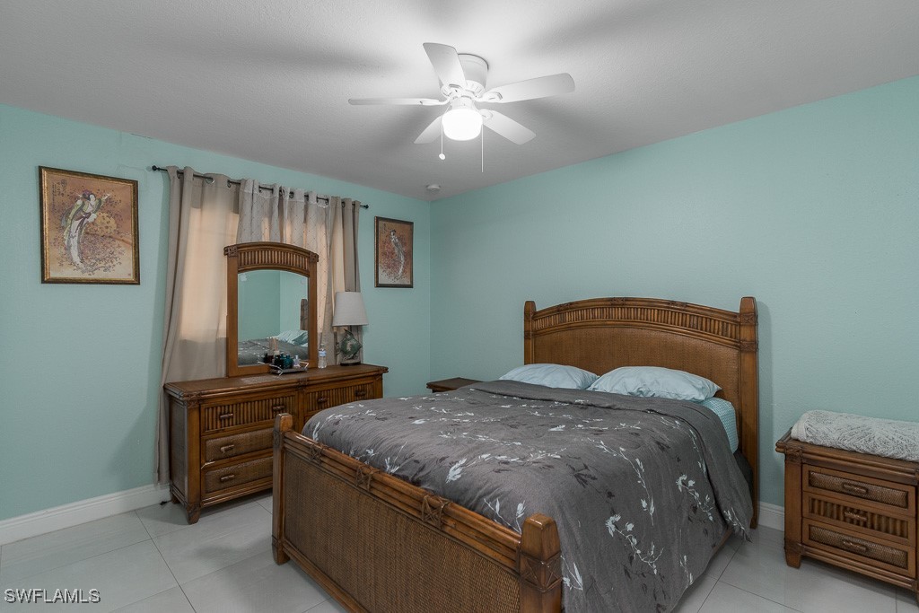 2808 9th Street Southwest Lehigh Acres, FL 33976 - Photo 11 of 34 a bedroom with a bed and a dresser with mirror