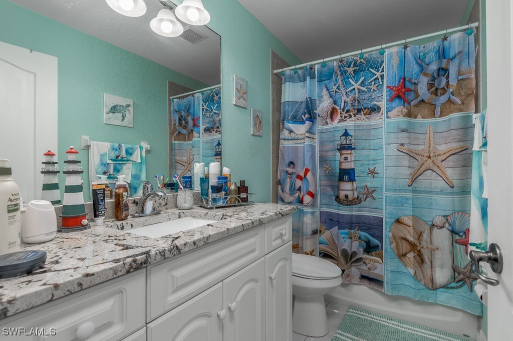 2808 9th Street Southwest Lehigh Acres, FL 33976 - Photo 12 of 34 a bathroom with a sink a mirror and toilet