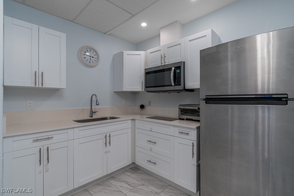 2808 9th Street Southwest Lehigh Acres, FL 33976 - Photo 20 of 34 a kitchen with a refrigerator sink and cabinets