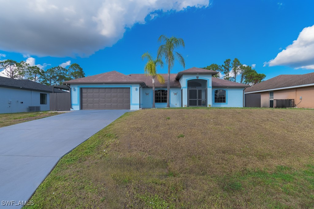 2808 9th Street Southwest Lehigh Acres, FL 33976 - Photo 25 of 34 a front view of a house with a yard and garage