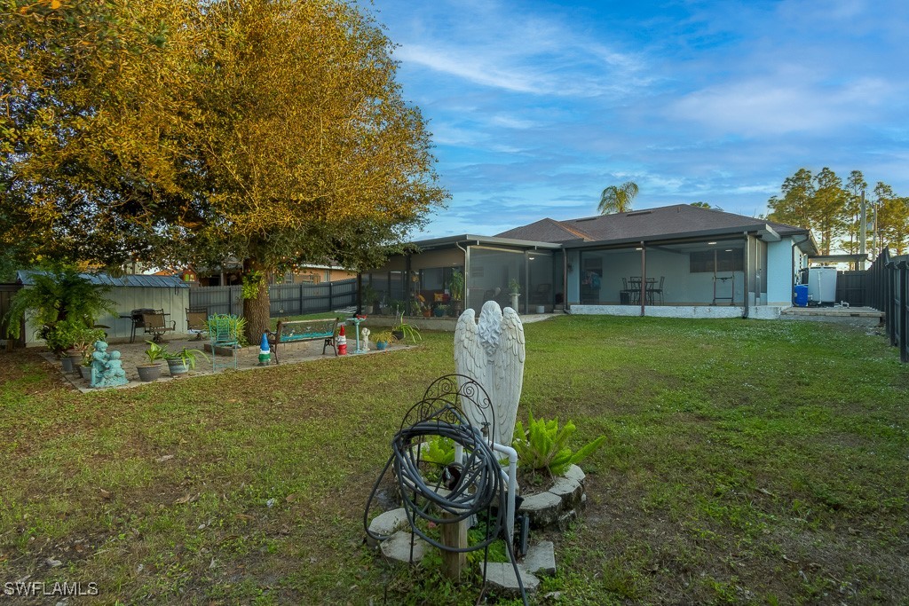 2808 9th Street Southwest Lehigh Acres, FL 33976 - Photo 26 of 34 a view of a house with backyard sitting area and garden