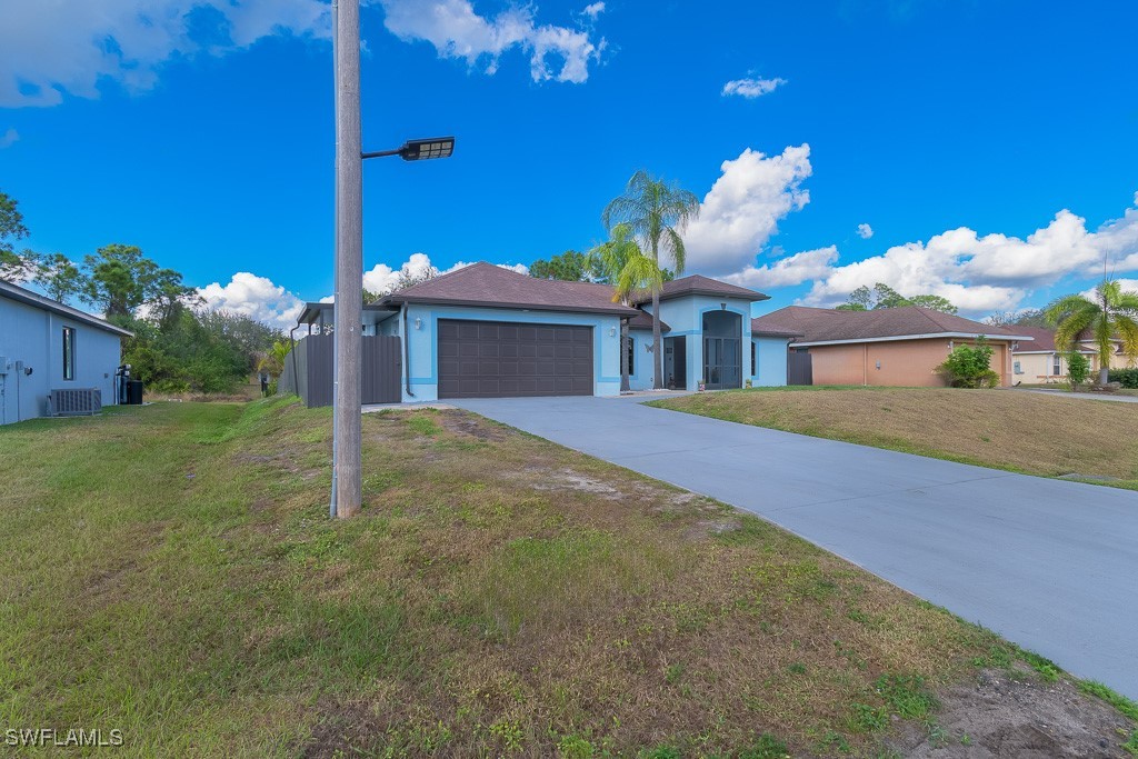 2808 9th Street Southwest Lehigh Acres, FL 33976 - Photo 29 of 34 a view of a house with a yard and potted plants