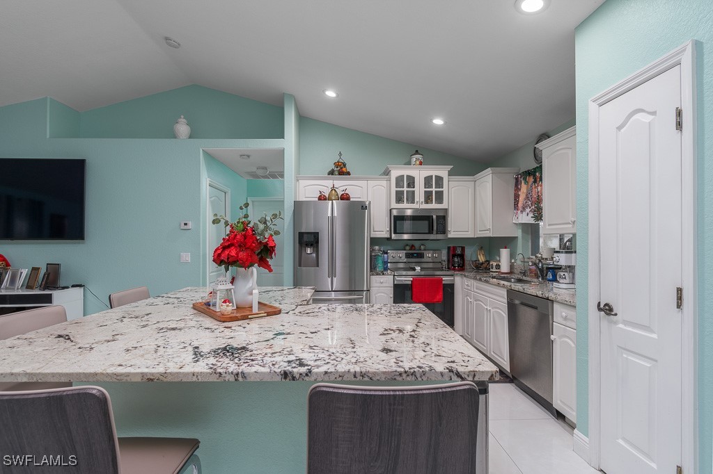 2808 9th Street Southwest Lehigh Acres, FL 33976 - Photo 5 of 34 a kitchen with stainless steel appliances granite countertop a sink refrigerator and cabinets