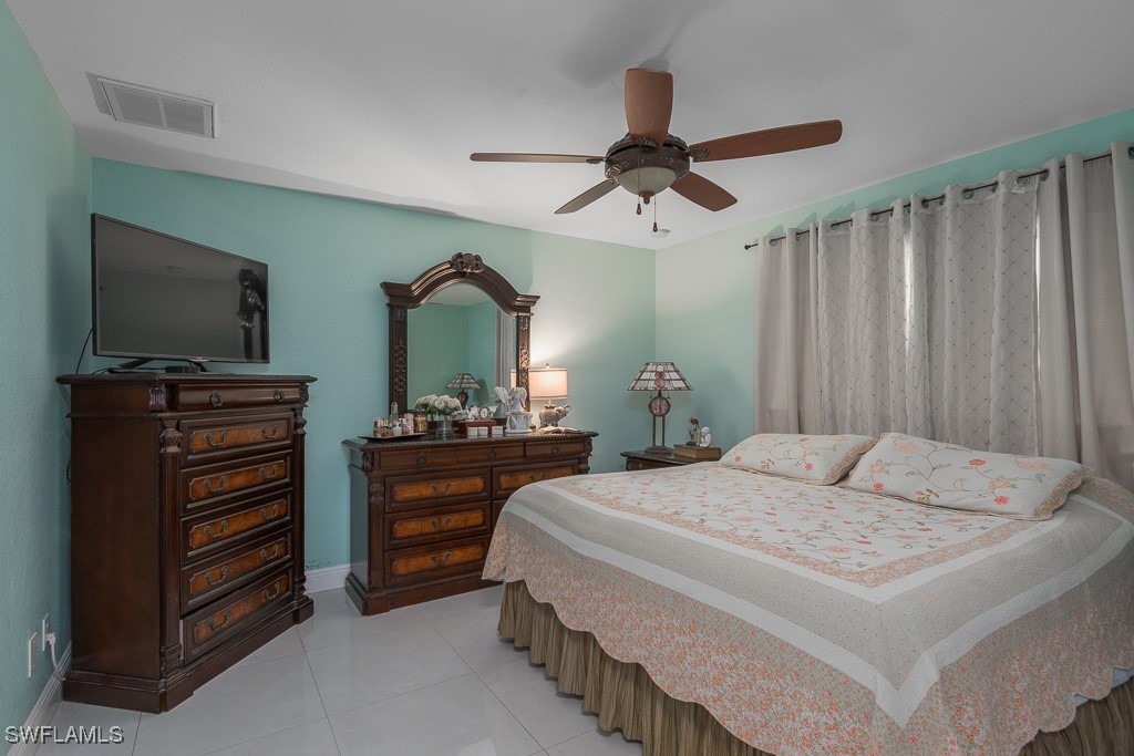 2808 9th Street Southwest Lehigh Acres, FL 33976 - Photo 6 of 34 a bedroom with a bed and a flat tv screen on dresser