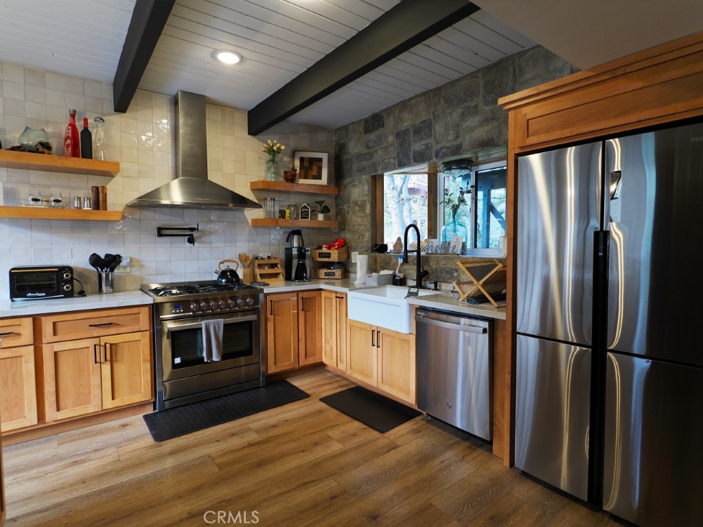 28596 North Bay Road Lake Arrowhead, CA 92352 - Photo 28 of 69 a kitchen with stainless steel appliances granite countertop a refrigerator a sink dishwasher a stove and white countertops with wooden floor