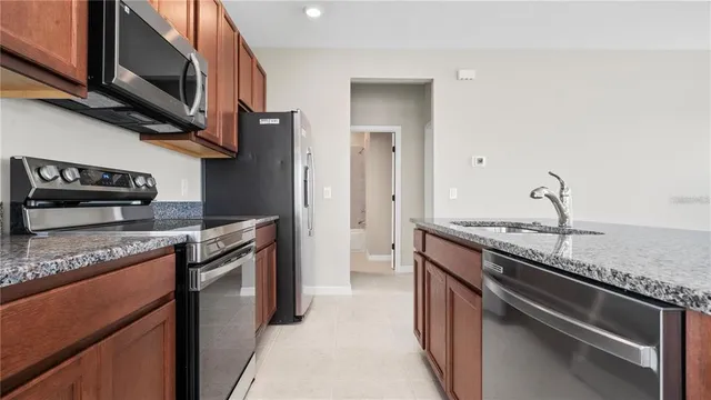 a kitchen with stainless steel appliances granite countertop a stove and a sink