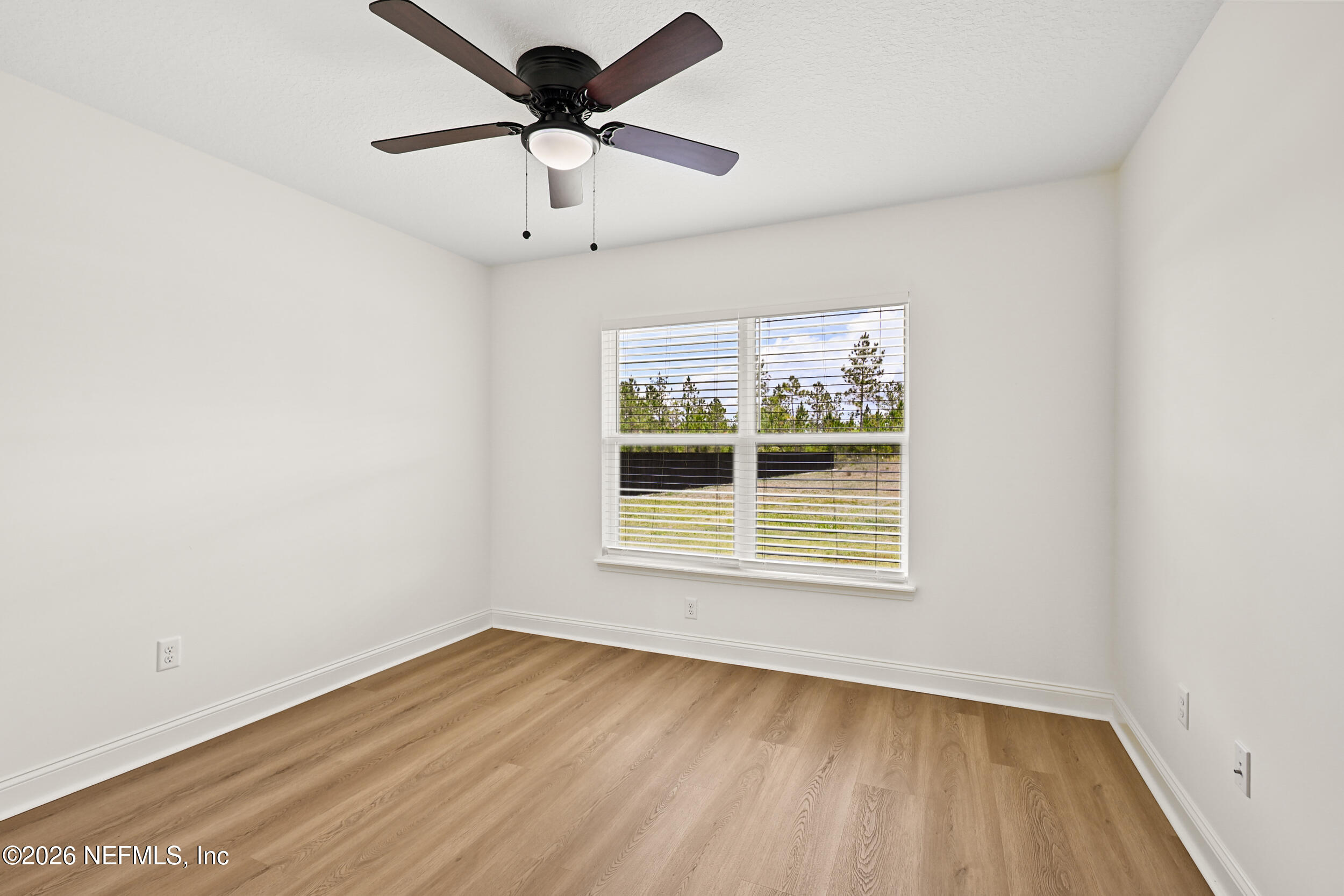 8685 Odis Yarborough Road Glen St. Mary, FL 32040 - Photo 36 of 59 an empty room with wooden floor and windows