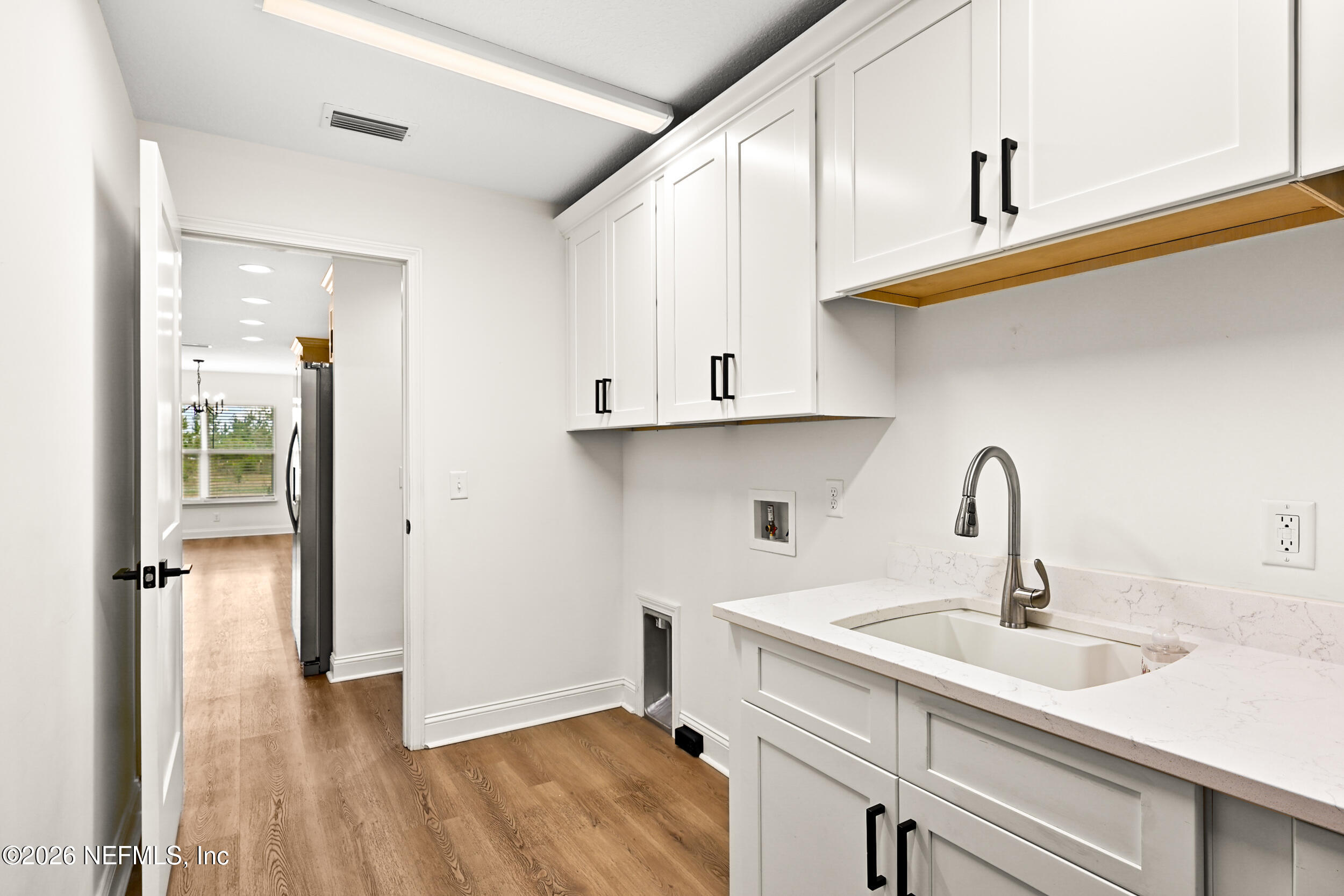 8685 Odis Yarborough Road Glen St. Mary, FL 32040 - Photo 42 of 59 a kitchen with sink cabinets and wooden floor