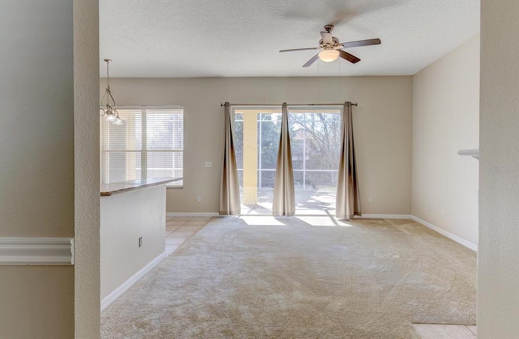 276 Longhirst Loop Ocoee, FL 34761 - Photo 12 of 60 an empty room with windows and chandelier fan