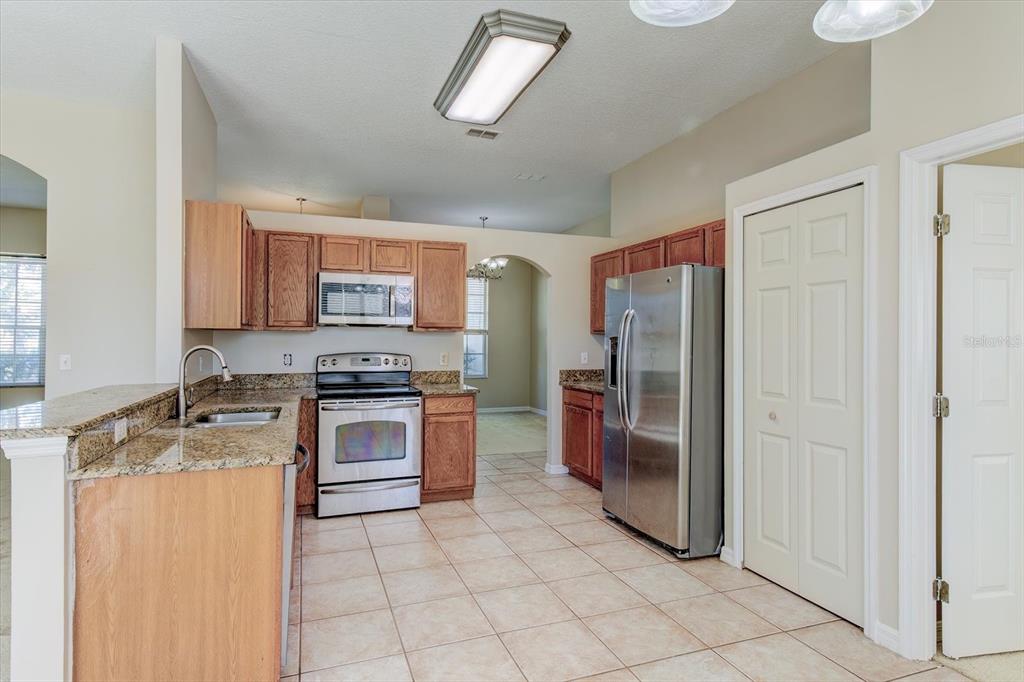 276 Longhirst Loop Ocoee, FL 34761 - Photo 17 of 60 a kitchen with stainless steel appliances granite countertop a refrigerator stove and sink