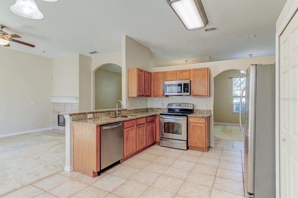 276 Longhirst Loop Ocoee, FL 34761 - Photo 18 of 60 a kitchen with stainless steel appliances granite countertop a stove a sink and a refrigerator