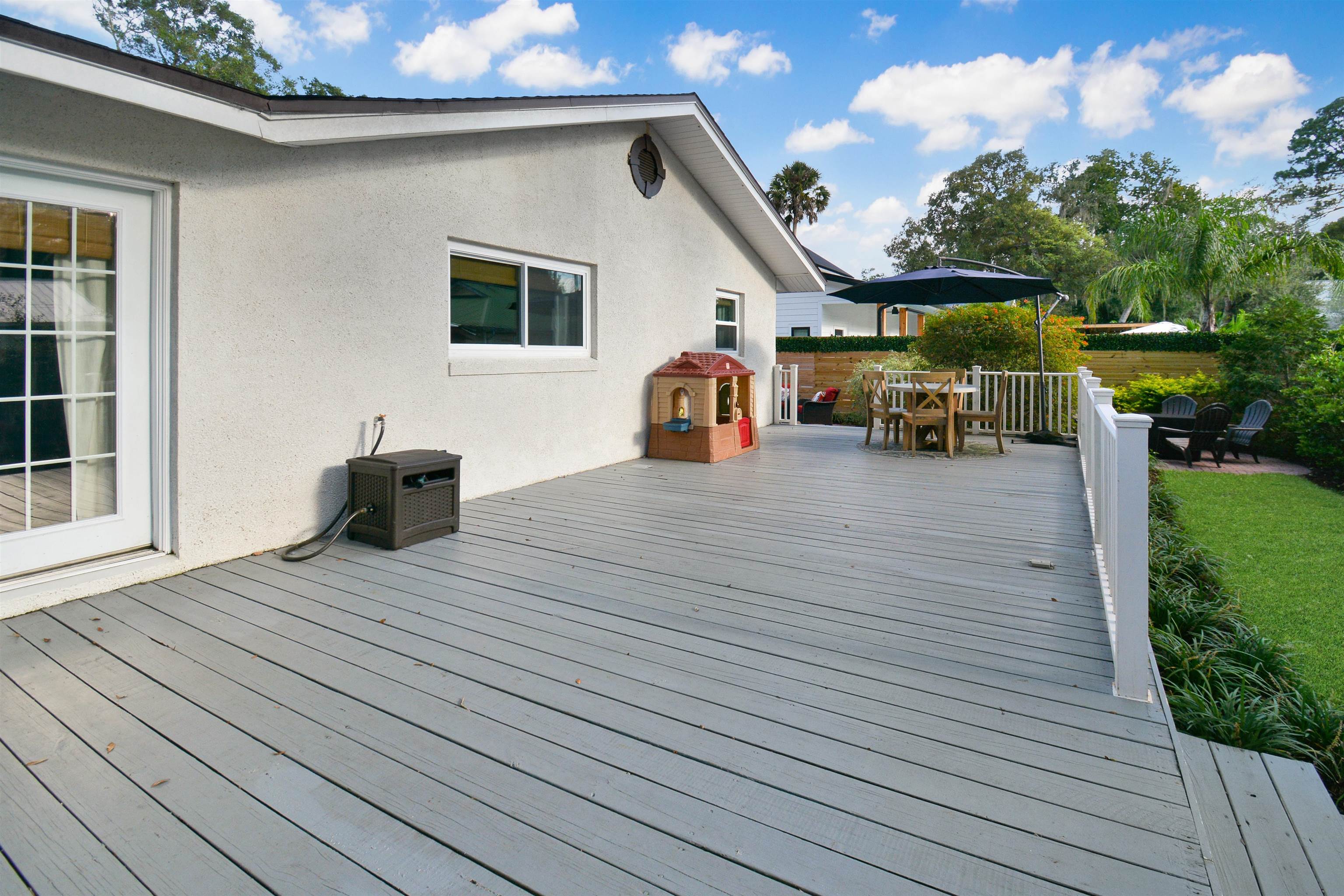156 Egret Road St. Augustine, FL 32086 - Photo 27 of 44 a view of a patio with table and chairs with wooden floor and fence