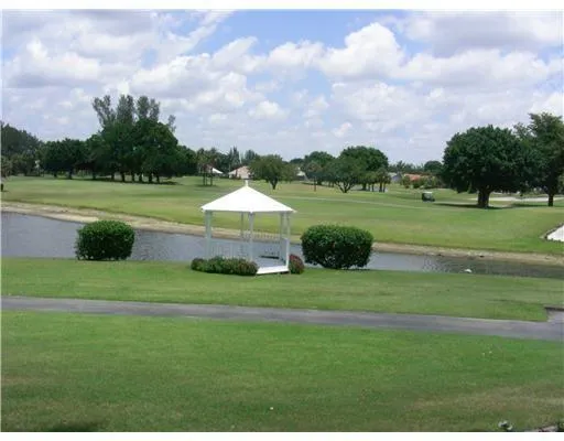 a view of a park with a big yard and potted plants