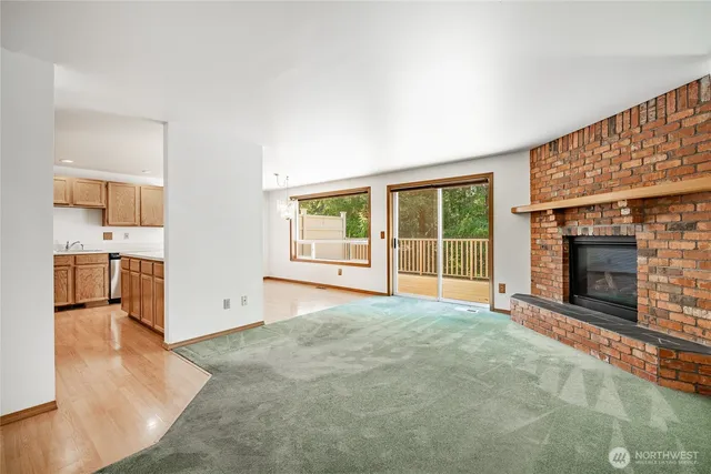 a view of an empty room with a fireplace and a window