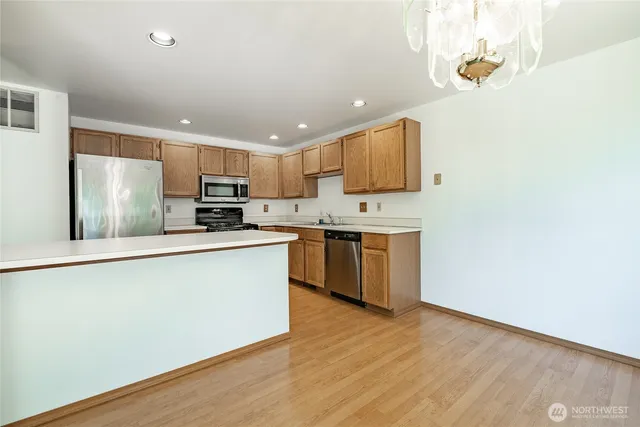 a kitchen with stainless steel appliances granite countertop a stove a sink and a refrigerator