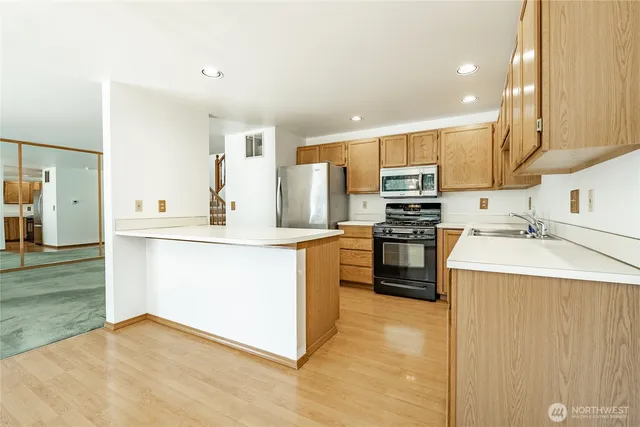 a kitchen with stainless steel appliances a refrigerator sink and stove