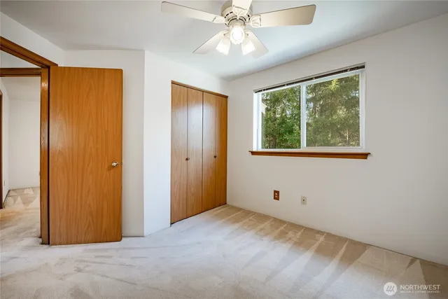 a view of an empty room with window closet area