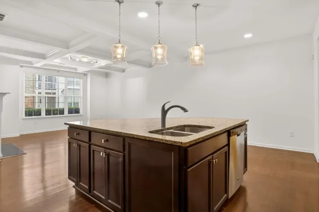 a kitchen that has a lot of cabinets and wooden floor