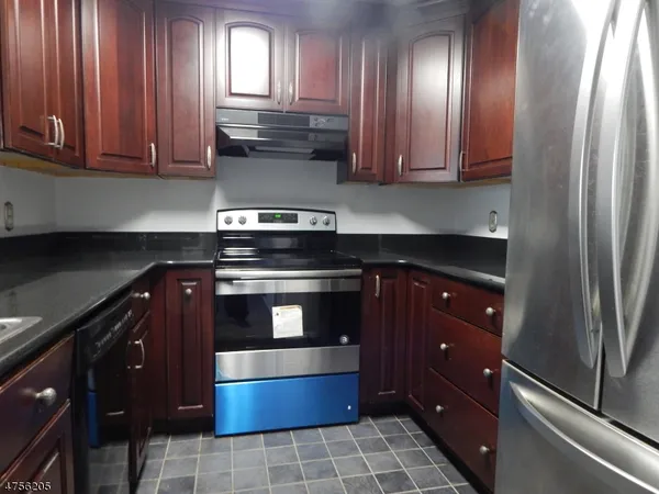a kitchen with stainless steel appliances granite countertop wood cabinets and a stove