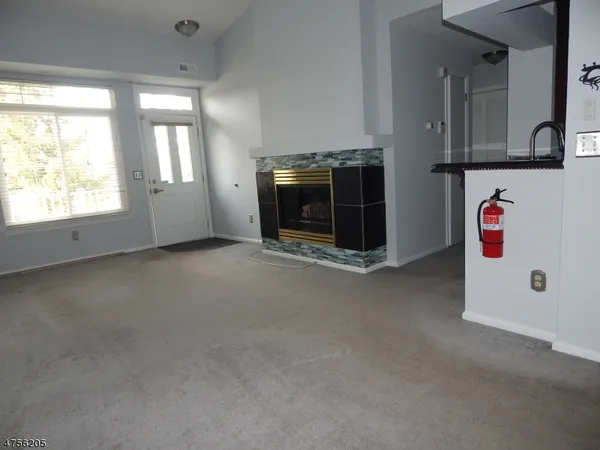 an empty room with windows and fireplace