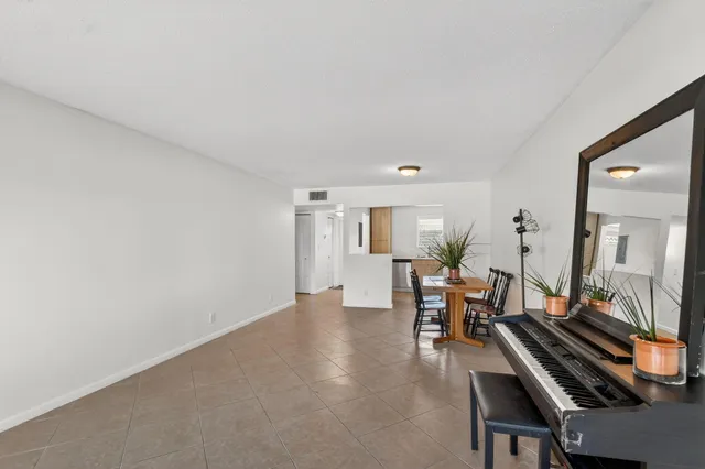 a view of house in front of a big yard with large trees