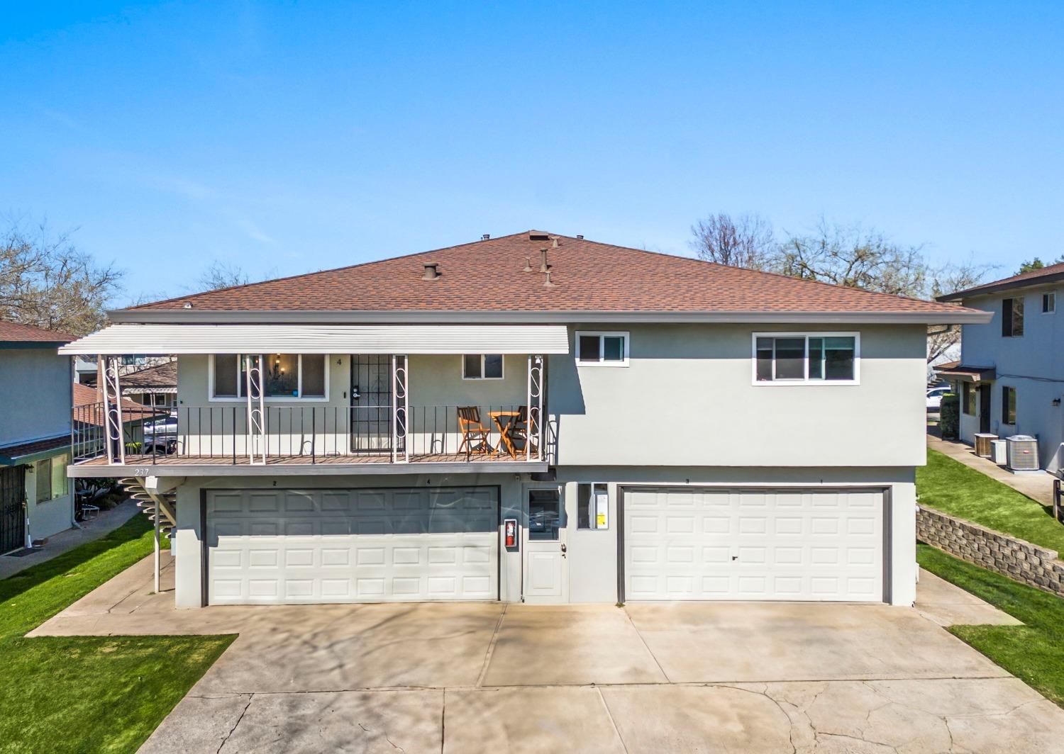 a front view of a house with a garden and sitting area