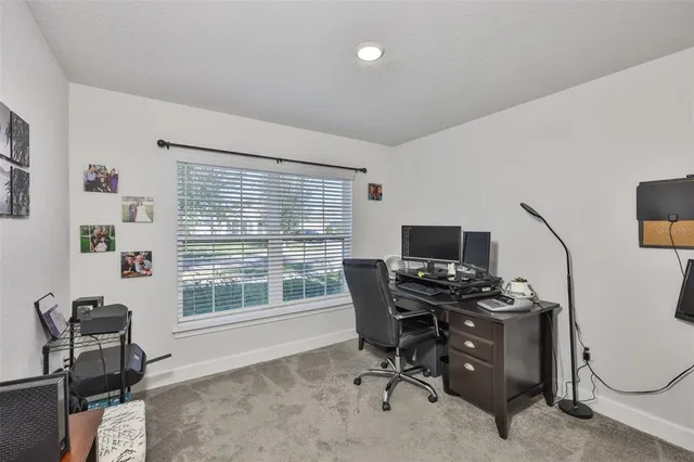 a view of a workspace with furniture and a window
