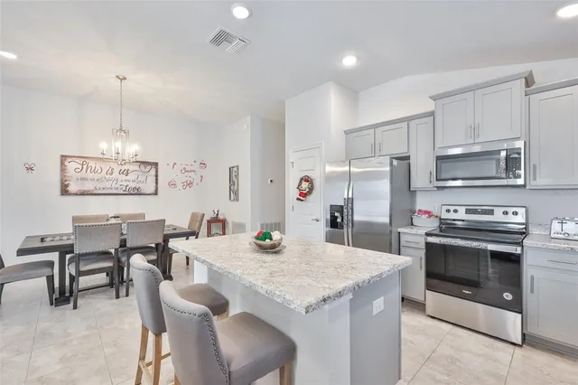 a kitchen with a stove a refrigerator and a dining table