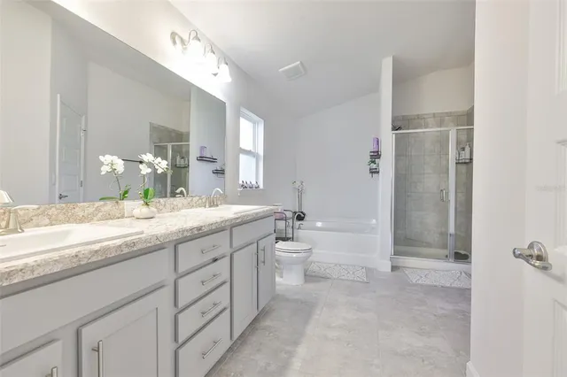 a bathroom with a granite countertop sink mirror and a bathtub