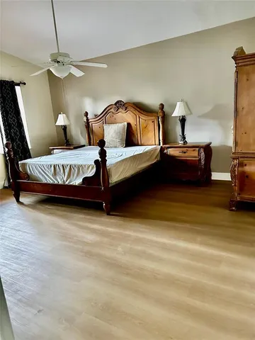 a bedroom with a bed and a flat tv screen on a dresser