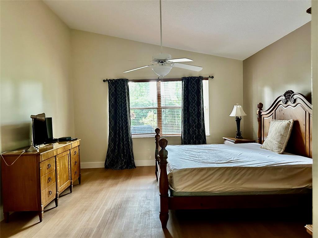 8564 Vía Giardino Boca Raton, FL 33433 - Photo 12 of 20 a bedroom with a bed and a flat tv screen on a dresser