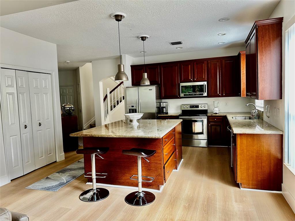 8564 Vía Giardino Boca Raton, FL 33433 - Photo 15 of 20 a kitchen with kitchen island granite countertop a sink appliances and cabinets