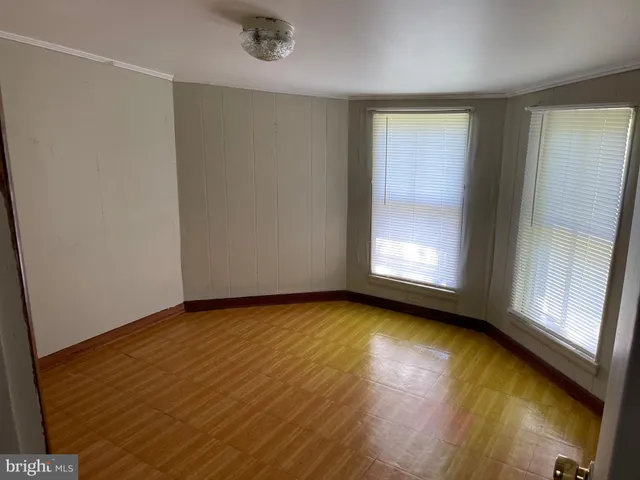 a view of a livingroom with wooden floor and a fireplace