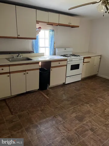 an empty room with wooden floor a fireplace and window