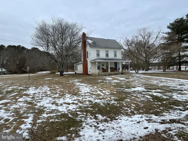 a view of a house with a yard covered in snow