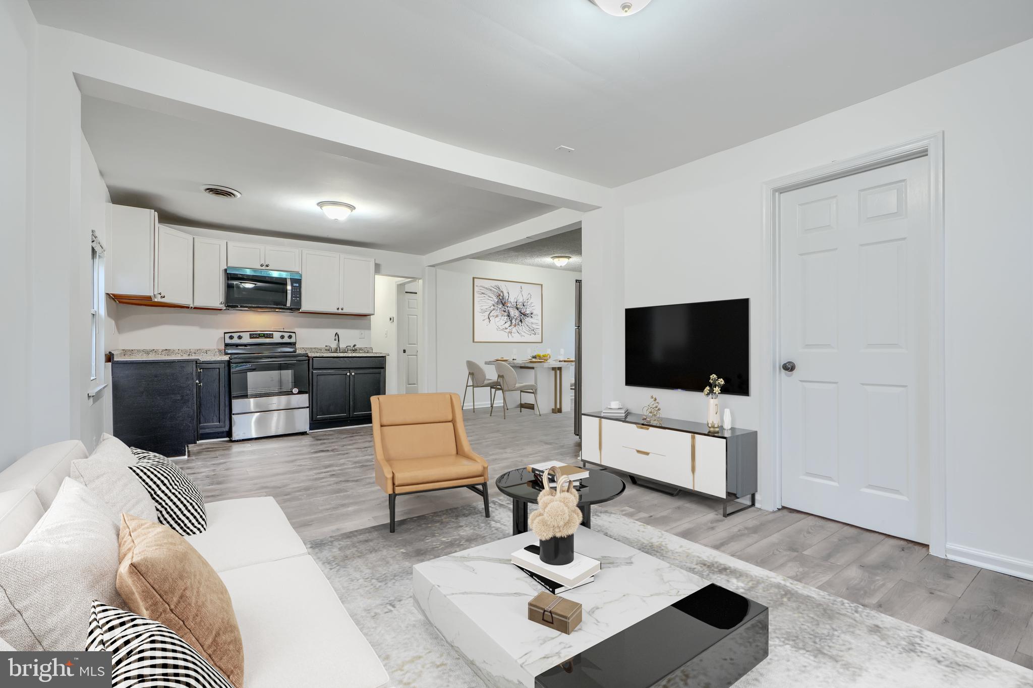 a living room with furniture a flat screen tv and a window