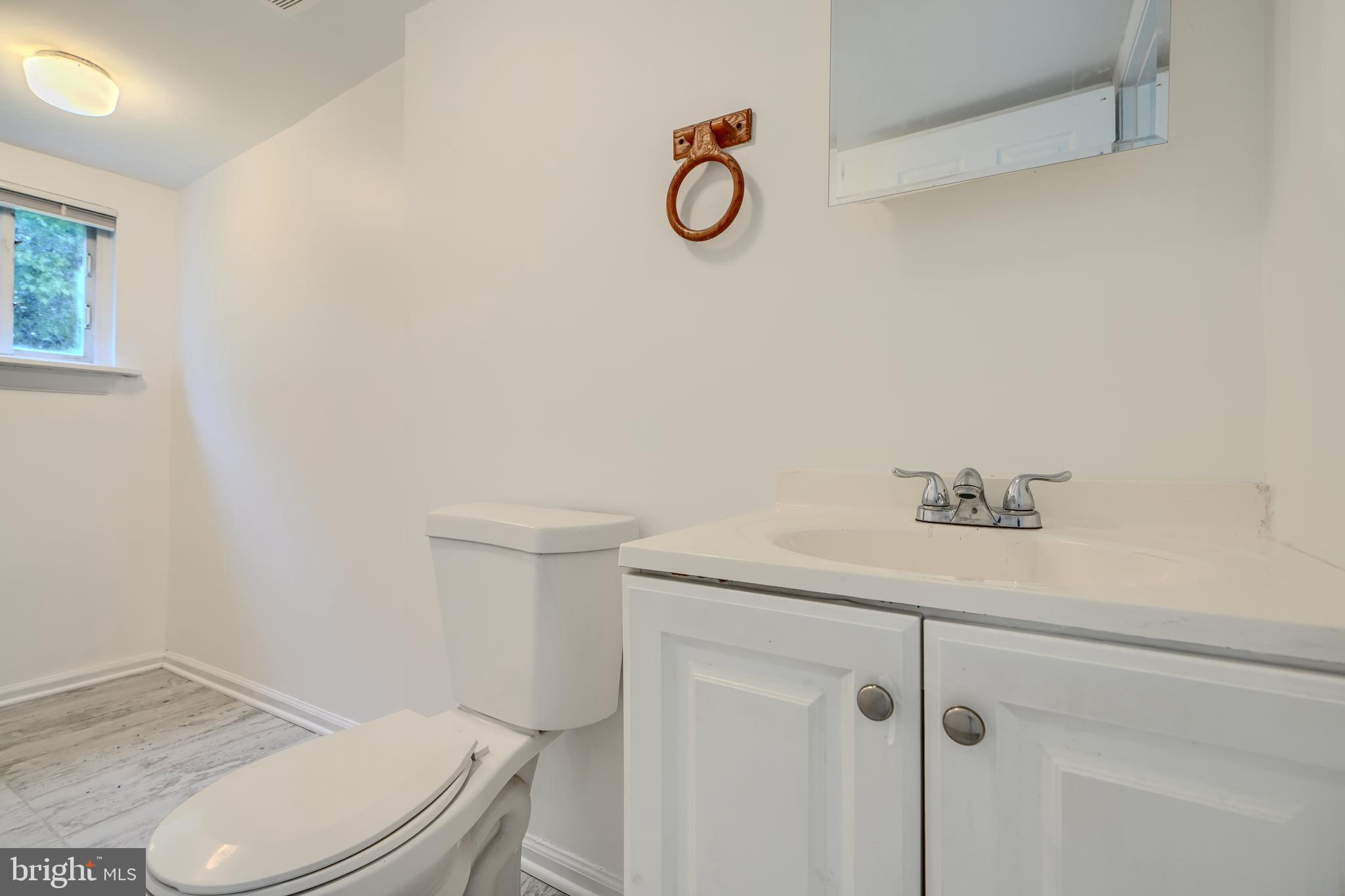 227 Elizabeth Avenue Baltimore, MD 21225 - Photo 11 of 31 a bathroom with a granite countertop toilet and a sink