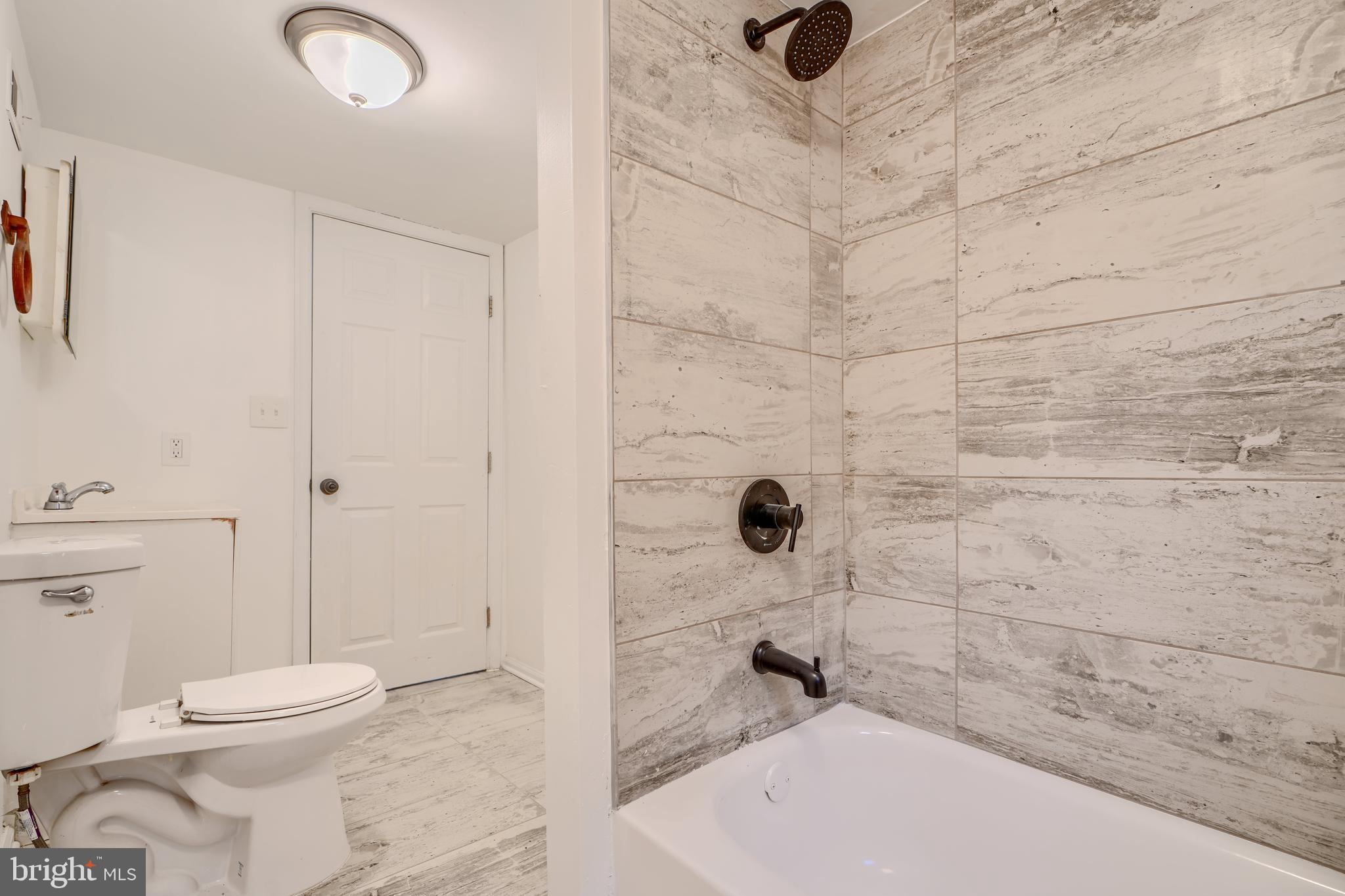 227 Elizabeth Avenue Baltimore, MD 21225 - Photo 13 of 31 a bathroom with a toilet and a shower